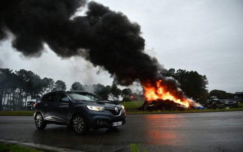 Un automóvil junto a un incendio de neumáticos durante una protesta convocada por el sindicato de agricultores franceses 'Coordinación Rural'.