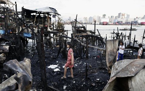 Niños caminan entre chabolas quemadas después de que se produjera un incendio en Manila, Filipinas, el 25 de noviembre de 2024.