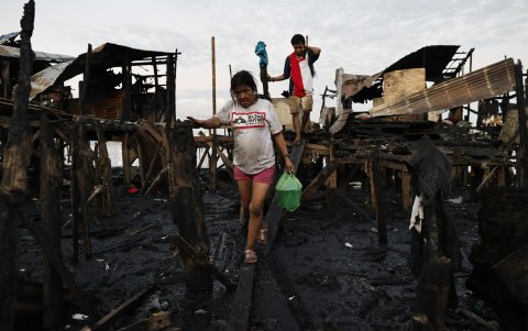 Los residentes cargan sus pertenencias recuperadas después de que se produjera un incendio en Manila, Filipinas, el 25 de noviembre de 2024.