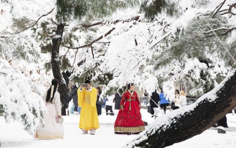 Turistas vestidos con vestidos tradicionales coreanos Hanbok toman fotos en medio de una nevada en el Palacio Gyeongbokgung en Seúl, este 27 de noviembre de 2024.