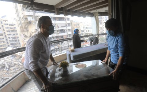 La gente limpia escombros y escombros de su apartamento en los suburbios del sur de Beirut el 27 de noviembre de 2024.