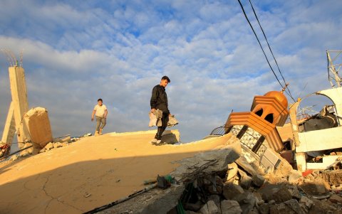 Un joven lleva copias del Corán que rescató de los escombros de una mezquita destruida en la aldea de Tair Debba, un día después de un acuerdo de alto el fuego entre Israel y Hizbulá.