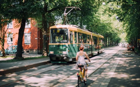 Chica en bicicleta y tranvía en calle Pohjolankatu.