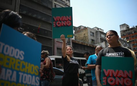 Una mujer sostiene un cartel que dice 