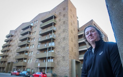 Tony Groves, podcaster y comentarista político, posa para una fotografía junto a un desarrollo de viviendas sociales en Dublín el 7 de noviembre de 2024.
