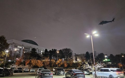Un helicóptero sobrevuela la Asamblea Nacional en Seúl poco después de que el presidente surcoreano, Yoon Suk Yeol, declarara la ley marcial en Seúl