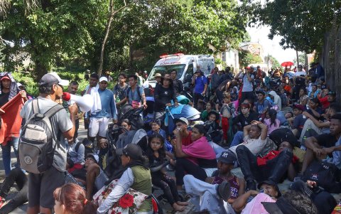 Migrantes descansan durante una caravana este martes, en el municipio de Huixtla (México).