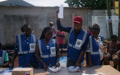 Los funcionarios electorales clasifican y cuentan las papeletas durante las elecciones generales en la Universidad de Wisconsin en Accra, Ghana.