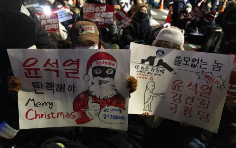 Los manifestantes sostienen pancartas que piden la destitución del presidente Yoon Suk Yeol durante una manifestación frente a la Asamblea Nacional en Seúl, Corea del Sur, el 9 de diciembre de 2024.
