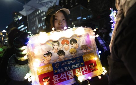 Un manifestante sostiene pancartas que piden el arresto del presidente Yoon Suk Yeol durante una manifestación frente a la Asamblea Nacional en Seúl, Corea del Sur, el 9 de diciembre de 2024.