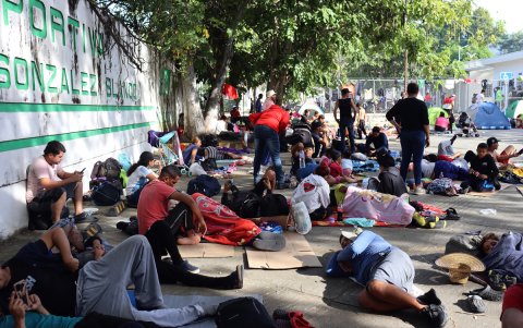 Migrantes descansan en un modulo deportivo.