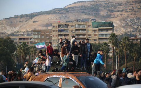Varias personas aparecen celebrando el derrocamiento del presidente sirio al-Assad, en la plaza Omeya de Damasco, Siria, el 9 de diciembre de 2024.
