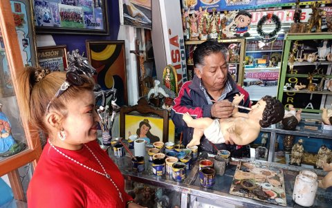 Una clienta llega al taller de don Renzo Vila para hacer restaurar una imagen para las fiestas de Navidad.