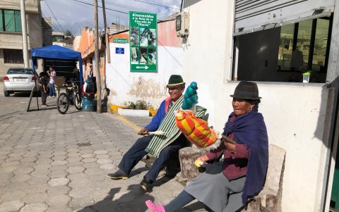 Tres adultos mayores en la plaza central de Tilipulo hilan algodón para no perder la tradición.
