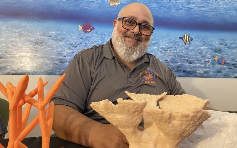 El presidente y cofundador de la Sociedad Ambiente Marino (SAM) de Puerto Rico, Samuel Suleiman, junto a unos corales creados con Ácido poliláctico.