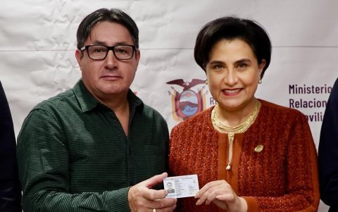 Proceso. Un migrante ecuatoriano posa con su nueva cédula junto a la canciller ecuatoriana, Gabriela Sommerfeld.