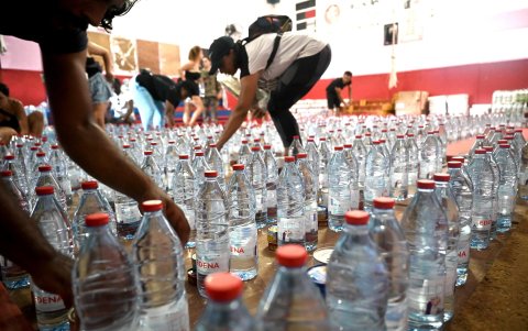 Voluntarios distribuyendo agua a la población en Pamandzi, isla de Petite-Terre, en el territorio francés de ultramar de Mayotte, el 18 de diciembre de 2024.