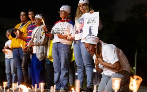 Personas participan durante una vigilia por los 