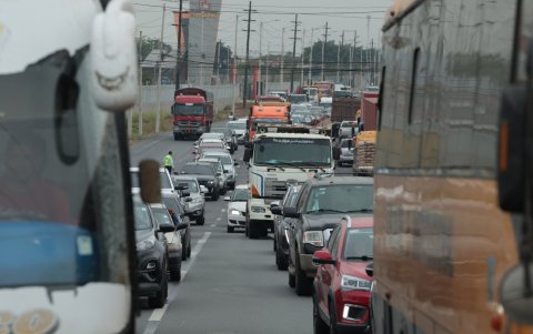 Tránsito. Vehículos livianos deben sortear los pesados tráileres y plataformas en la avenida León Febres-Cordero, en la parroquia dauleña La Aurora. Conductores exigen restricciones.