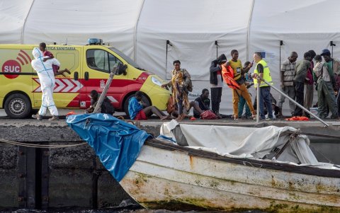 Miembros de la Cruz Roja Española sostienen a los niños después de que una embarcación 'cayuca' con 57 inmigrantes a bordo llegara al puerto de La Restinga.