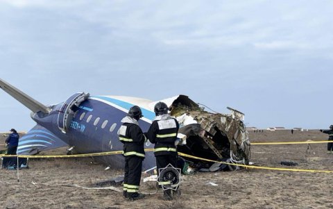 Miembros de los servicios de emergencias examinan los restos del avión de las líneas áereas de Azerbaiyán (AZAL) que se estrelló en el oeste de Kazajistán. E