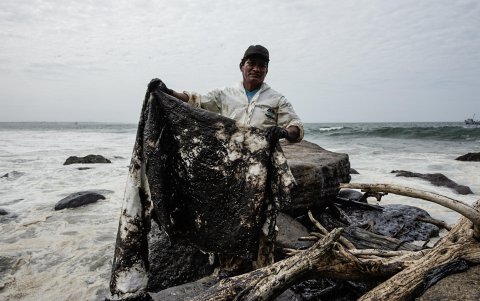 Un trabajador de Petroperú limpia un derrame de petroleo este lunes en la playa La Capullana, distrito de Lobitos en la provincia de Talara, en el norte de Perú.
