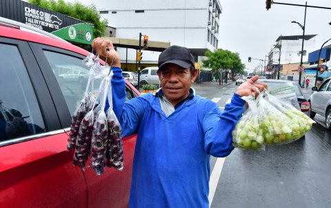 Venta. Un comerciante vende uvas y cereza en la avenida Esmeraldas.