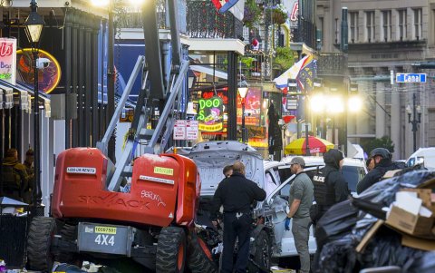 Investigadores de la policía rodean un camión blanco que se estrelló contra un ascensor de trabajo en el Barrio Francés