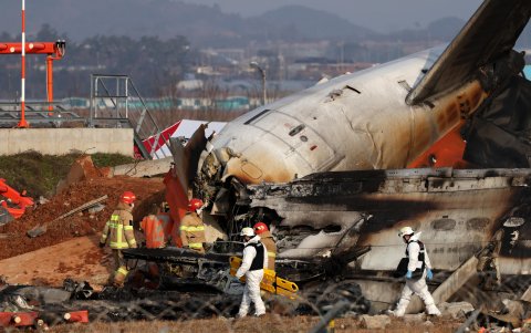 Integrantes del cuerpo del bomberos trabaja en los restos del avión de Jeju Ai