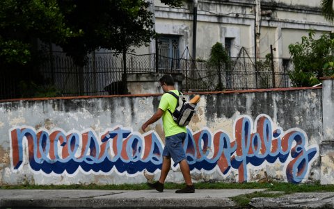 Un hombre pasa junto a un grafiti que dice 