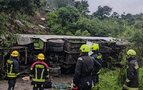 Fotografía cedida por los Bomberos de Ipiales de un grupo de bomberos y socorristas que trabajan en el lugar donde ocurrió el accidente de un bus.