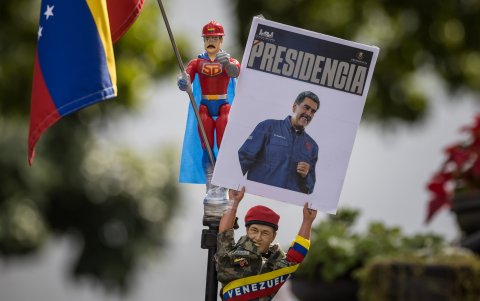 - Una persona sostiene un muñeco que representa al fallecido presidente de Venezuela Hugo Chávez con un cartel con la imagen del presidente de Venezuela, Nicolás Maduro