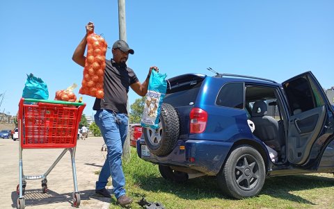 Un hombre carga alimentos en su automóvil afuera de un supermercado en Maputo el 27 de diciembre de 2024.