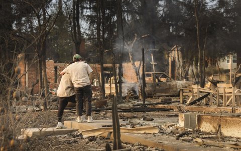 Dos personas se abrazan mientras miran los restos de una casa que fue destruida por el incendio forestal de Eaton en Altadena, California, EE. UU., el 9 de enero de 2025.