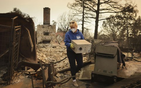 Melissa Young lleva algunas pertenencias restantes de los restos de su casa que fue destruida por el incendio forestal de Eaton en Altadena.