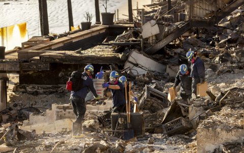 Palisades. Varios médicos forenses registran casa destruida por el incendio.