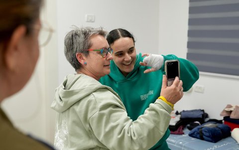 Emily Damari, con dedos mutilados, se saluda con su madre.