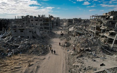 Palestinos desplazados internos caminan por una calle entre los escombros de edificios destruidos en medio de un alto el fuego, en Rafah, sur de la Franja de Gaza, el 20 de enero de 2025.