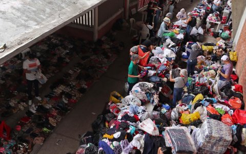 Personas clasifican algunas prendas que fueron donadas para los desplazados por la violencia en el Catatumbo este lunes, en el estadio General Santander en Cúcuta (Colombia).