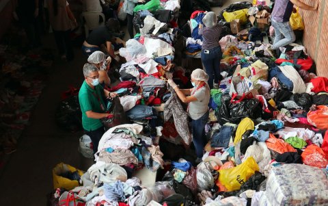 Personas clasifican algunas prendas que fueron donadas para los desplazados por la violencia en el Catatumbo este lunes, en el estadio General Santander en Cúcuta (Colombia).