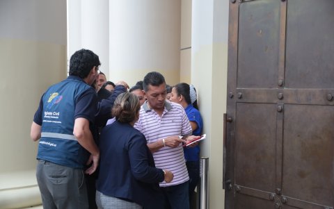 Las personas hablan una por una con los agentes del Registro Civil, quienes los guían en la entrada.