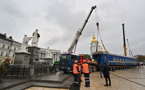 Los trabajadores descargan de un camión un vagón de tren que fue derribado por tropas rusas durante la evacuación de civiles de la ciudad de Irpin en marzo de 2023.