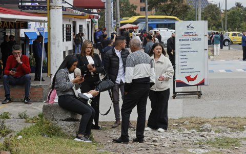 Ciudadanos colombianos solicitantes de visa de los Estados Unidos esperan información este lunes, cerca a la sede de la embajada de los Estados Unidos en Bogotá (Colombia).
