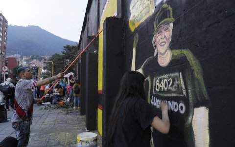 Integrantes de colectivos artísticos pintan un grafiti este viernes en Bogotá (Colombia).