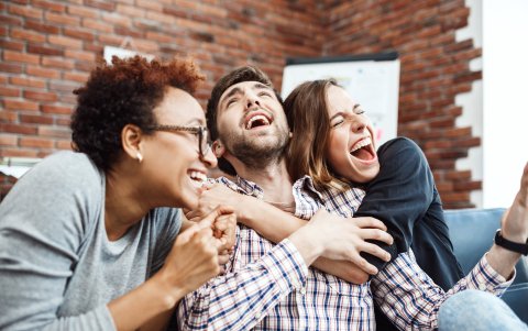 Colleagues rejoicing their work, shouting, embracing at business meeting.
