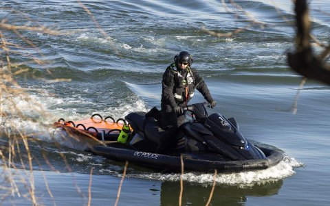 Un oficial de policía flota a lo largo de las orillas del río Potomac buscando escombros y restos de un avión comercial que chocó con un helicóptero militar, el 30 de enero de 2025.