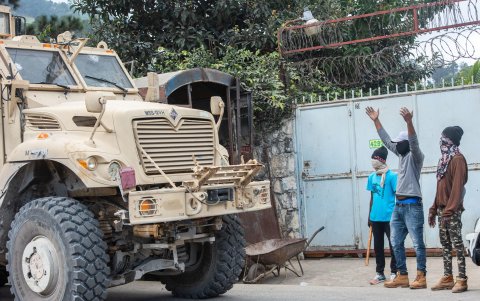Integrantes de una brigada de protección barrial dan acceso a un camión blindado del ejército haitiano este miércoles, en Kenscoff (Haití).
