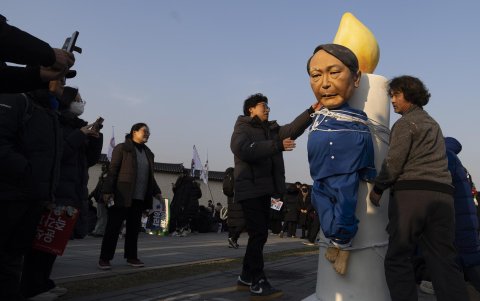Los manifestantes miran una efigie que representa al presidente de Corea del Sur, Yoon Suk Yeol (2-R), durante un mitin que exige la renuncia del presidente de Corea del Sur, Yoon.