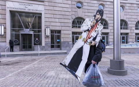 Un empleado de la Agencia de Ayuda al Desarrollo Internacional (Usaid) sale de la sede de la agencia llevando una silueta de cartón del cantante Elvis Presley, este lunes en Washington DC.