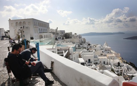 La gente revisa sus teléfonos móviles en la isla de Santorini, Grecia, el 4 de febrero de 2025.
